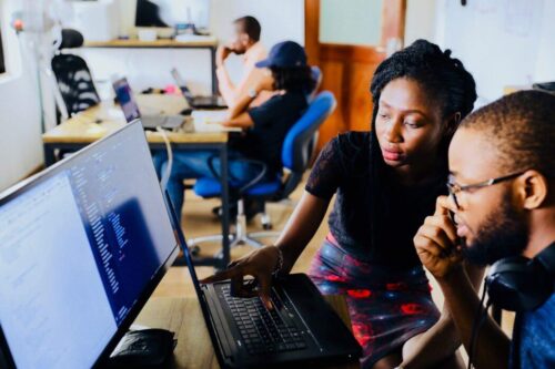 A student and mentor look at a computer screen