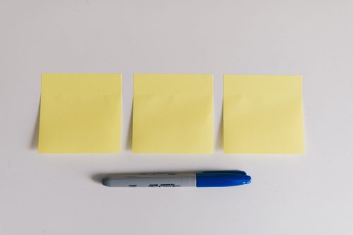 three post it notes - blank and a blue sharpie